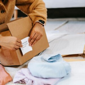 hands putting a shipping label on a  box