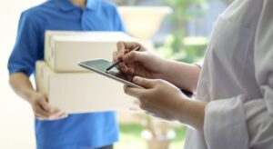 woman holding tablet while receiving delivery