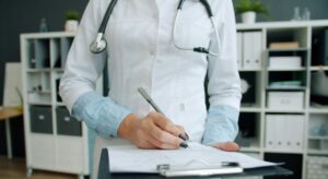doctor making notes on medical document