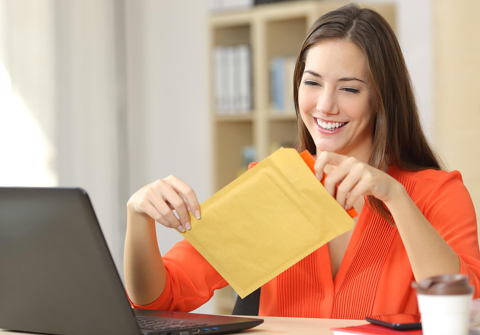 a woman opening an envelope with a paycheck inside